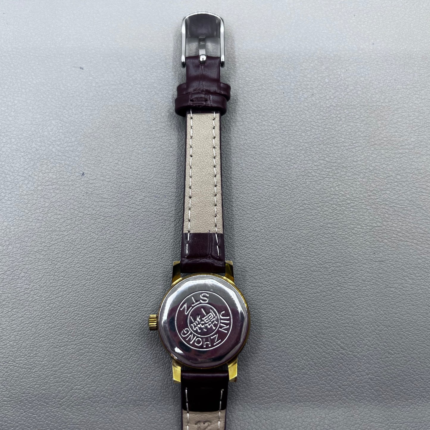 Dark Brown Strap Round Case 3 Hands Purple Background Manual Mechanical Watch