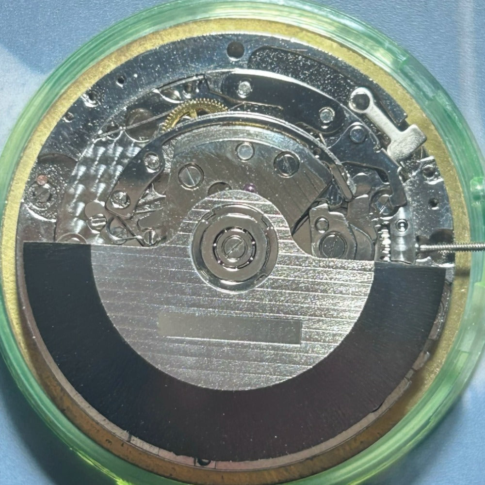 Dandong 7750 mechanical watch movement with small seconds at 6, 9, and 12 o'clock on black dial, precision-engineered.