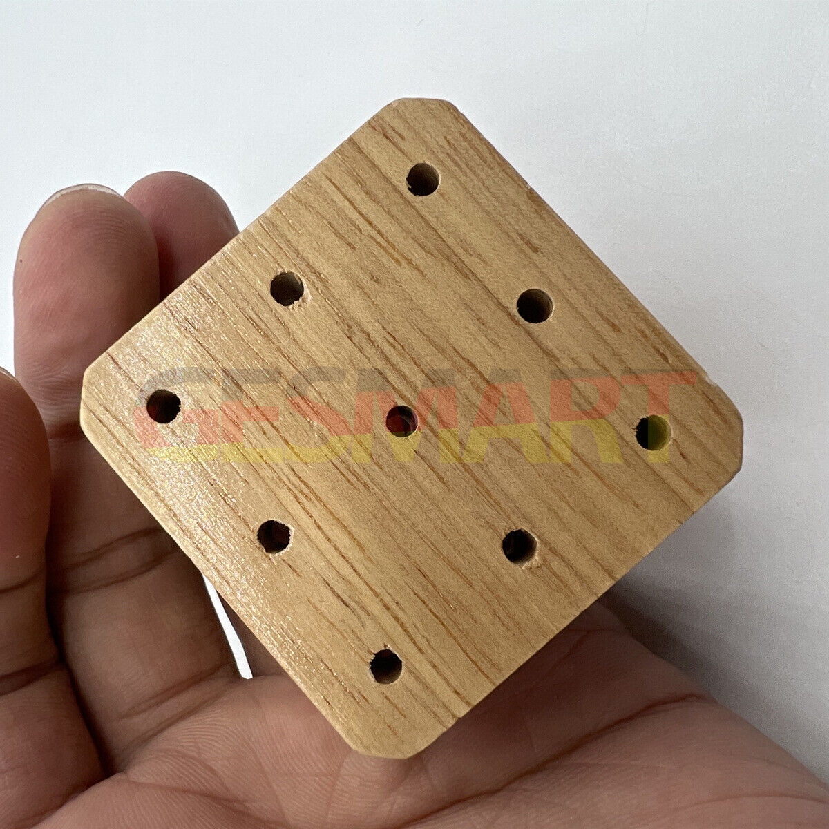 Wooden watch band holder with strap pins remover tool for precise watch repair.