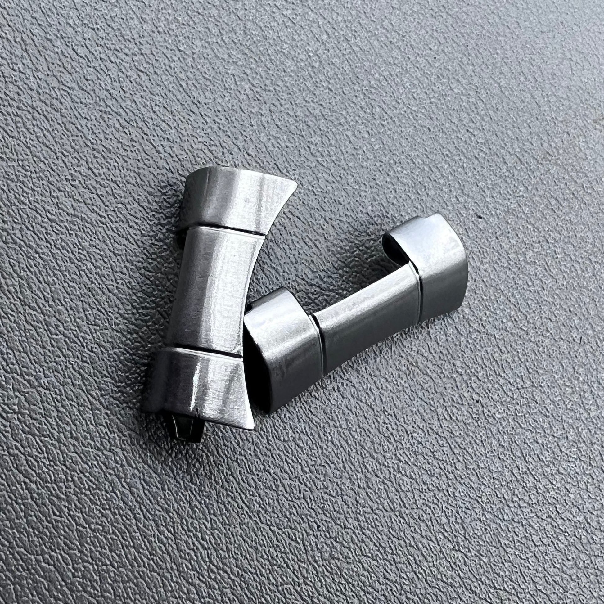 Set of 2 polished silver steel curved end links, 20x10mm, for secure watch band attachment.