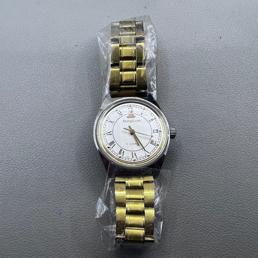 32mm golden stainless steel manual watch with 17 jewels and Roman numeral dial.