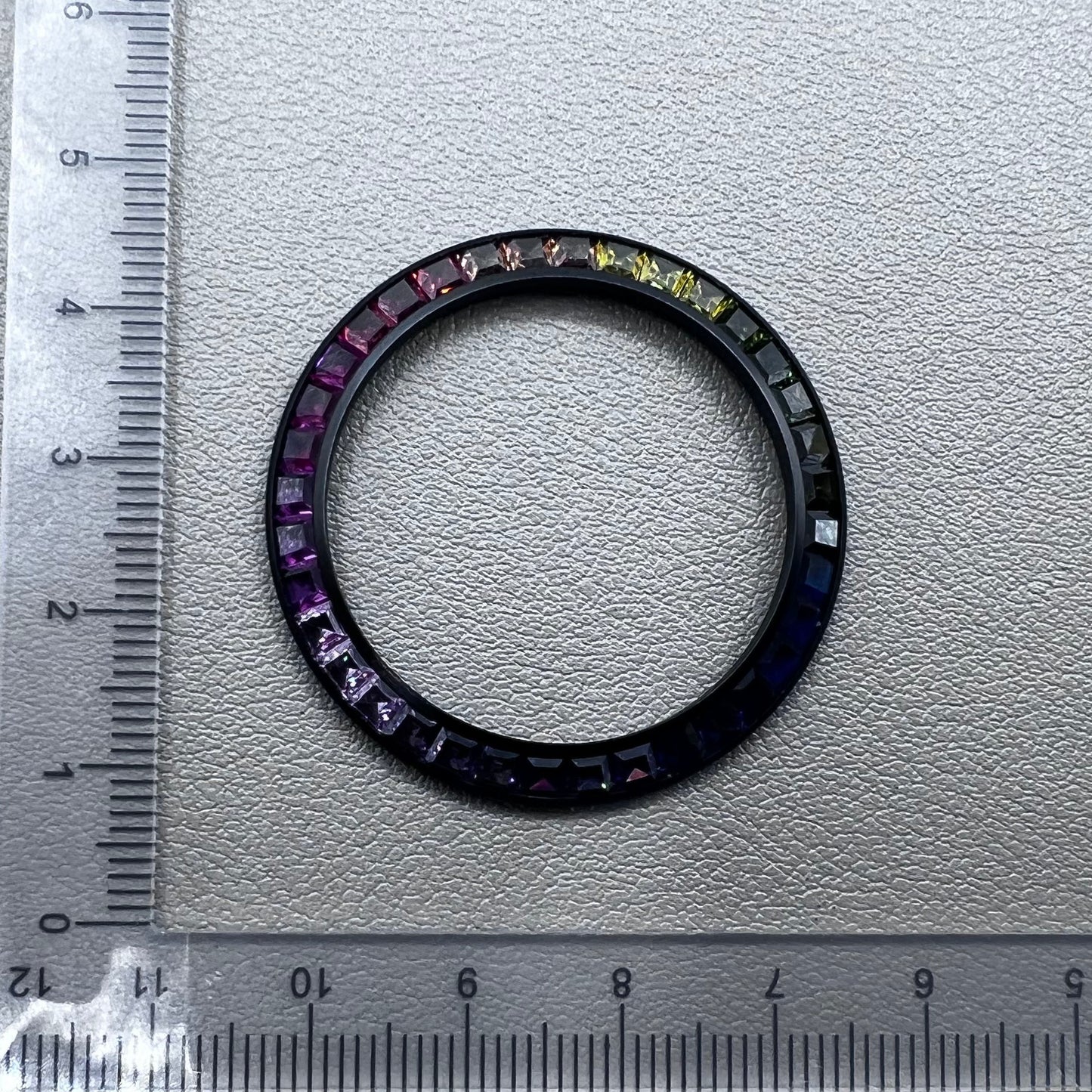 Daytona T-Shaped Square Moissanite watch bezel with inclined rainbow design on black base, luxury brand accessory.