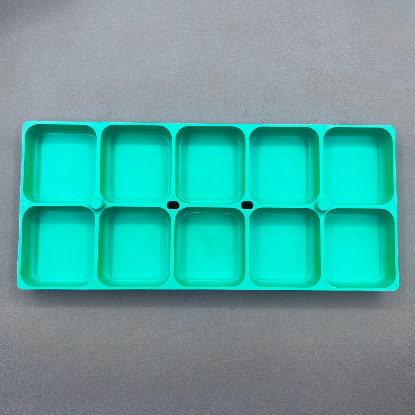Swiss Horotec green plastic container with 10 compartments for organizing watch accessories.