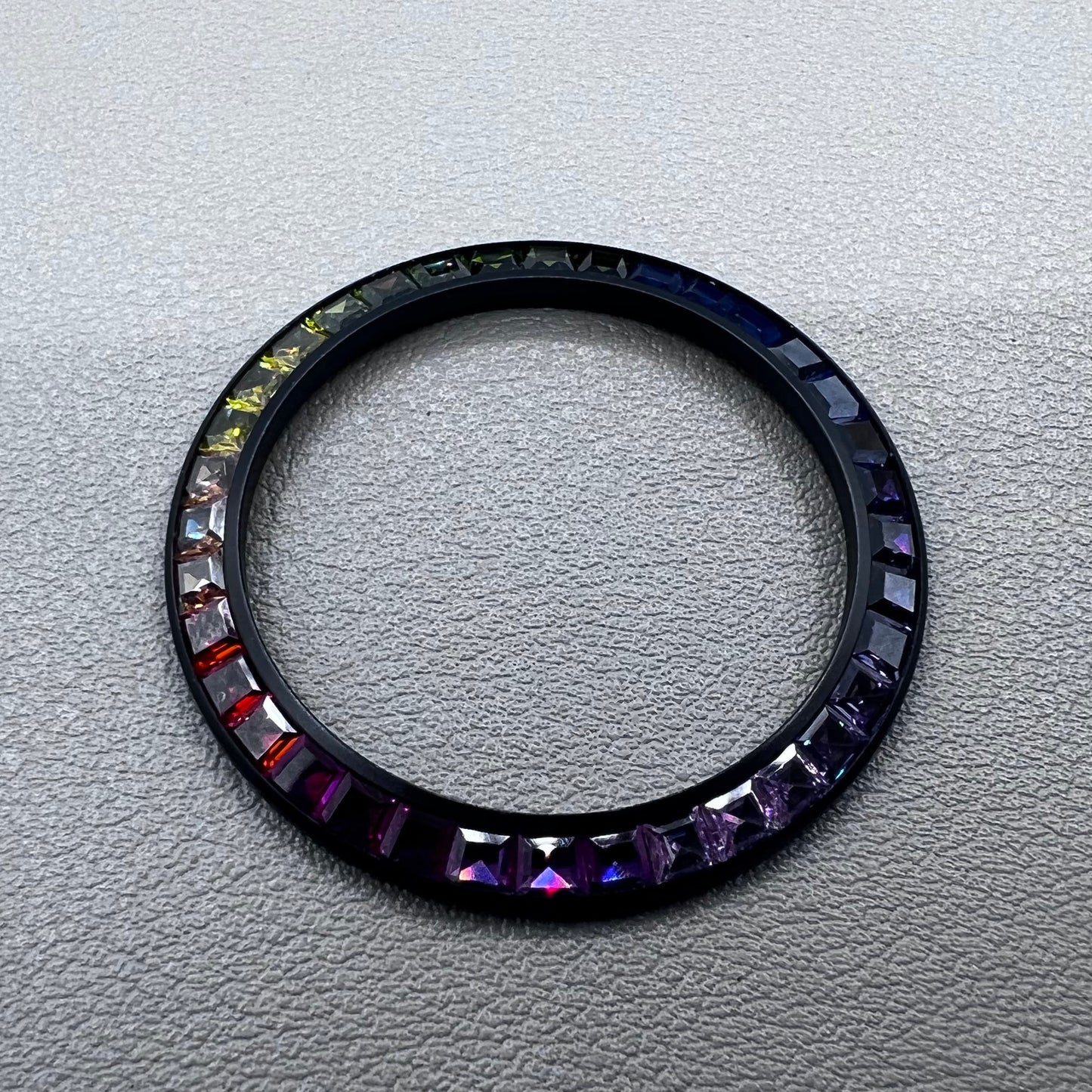 Daytona T-Shaped Square Moissanite watch bezel with inclined rainbow design on black base, luxury brand accessory.
