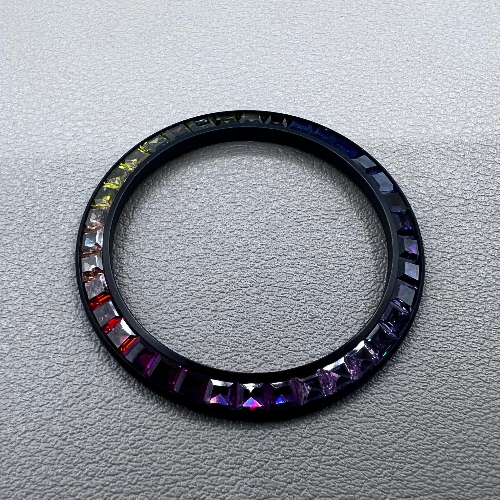 Daytona T-Shaped Square Moissanite watch bezel with inclined rainbow design on black base, luxury brand accessory.