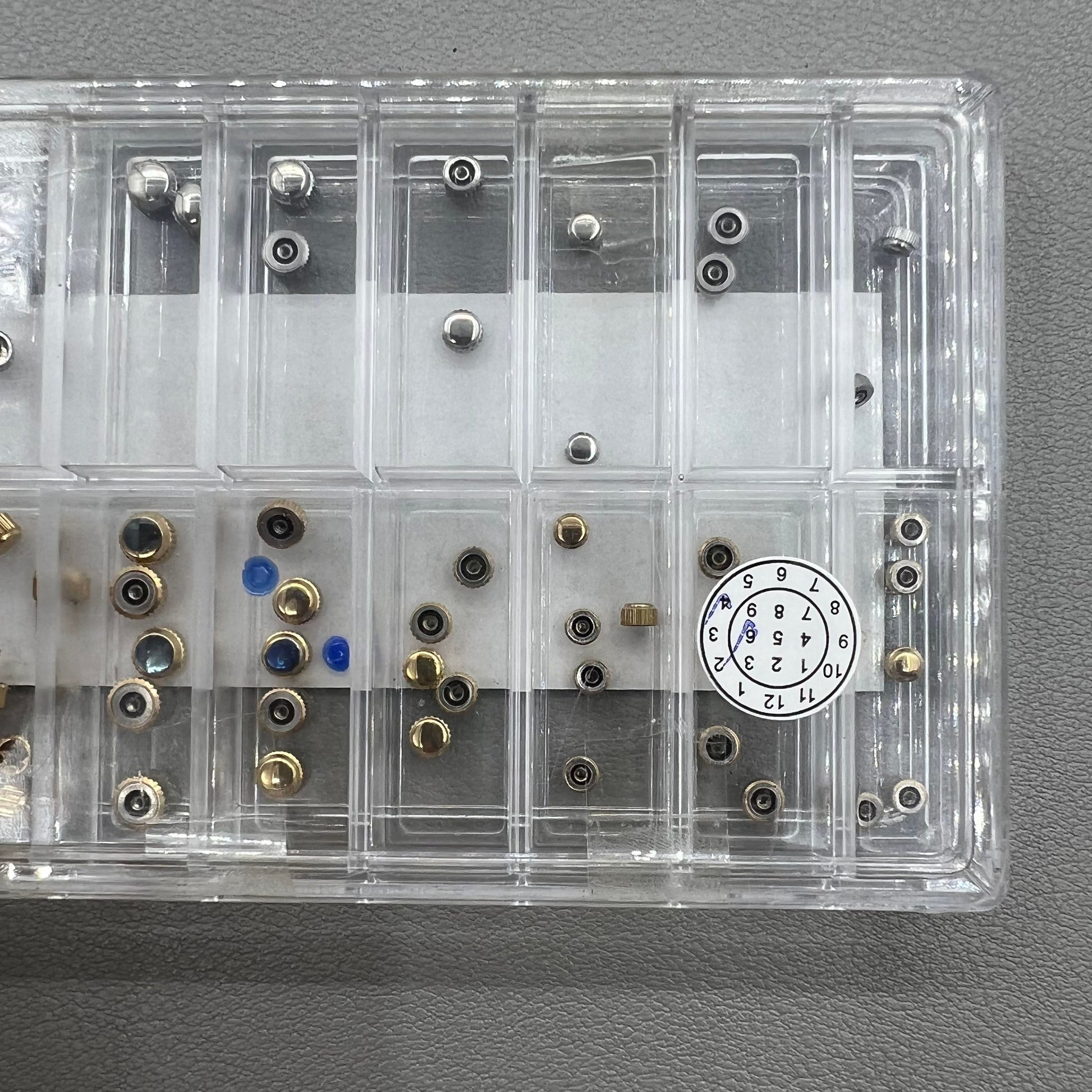 Set of 63 stainless steel watch crowns in gold and silver with 0.9mm diameter for repairs and customization.