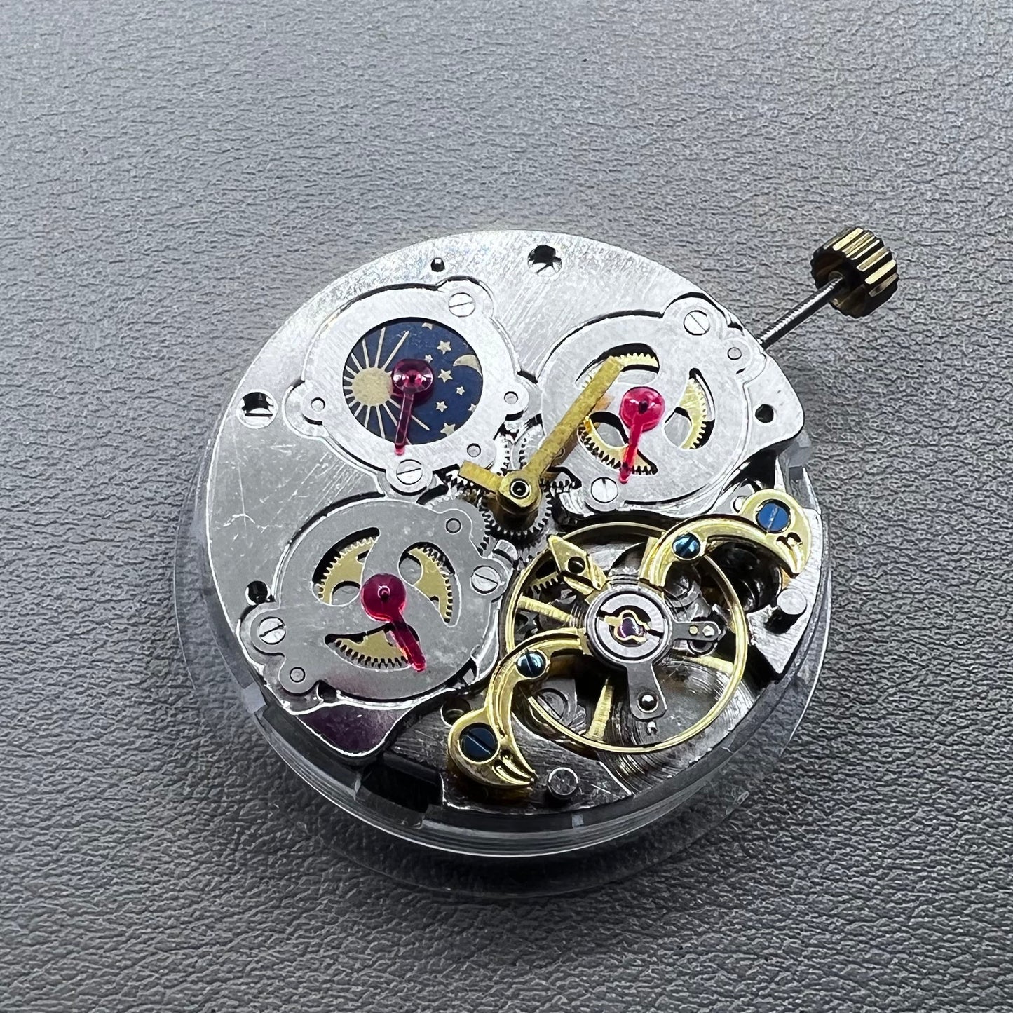 China multifunctional automatic watch with mechanical movement, moon phase at 12 o?clock, and visible flywheel detail