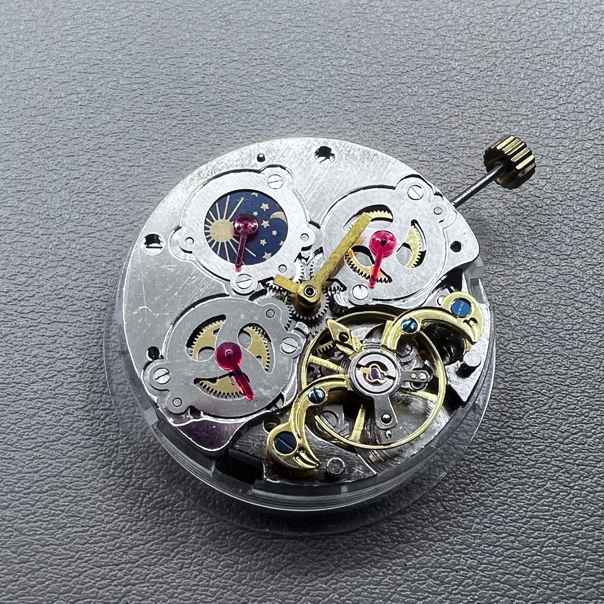 China multifunctional automatic watch with mechanical movement, moon phase at 12 o?clock, and visible flywheel detail