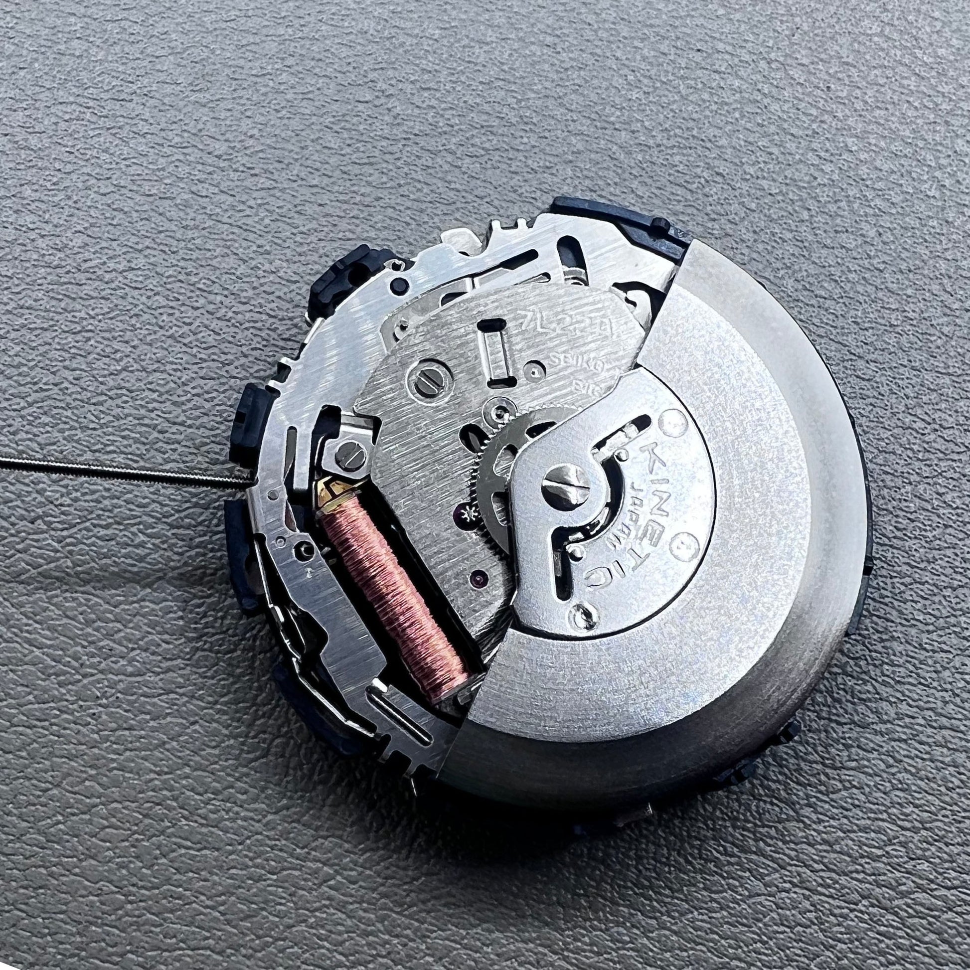 Original Japan Seiko 7L22A Quartz watch movement with black disk for precise timekeeping.