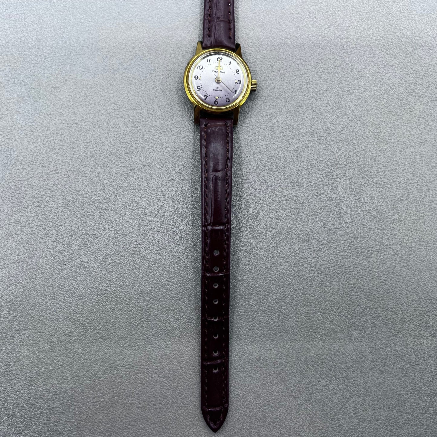 Dark Brown Strap Round Case 3 Hands Purple Background Manual Mechanical Watch