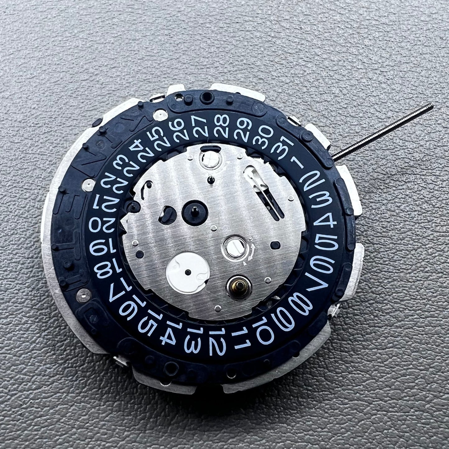 Original Japan Seiko 7L22A Quartz watch movement with black disk for precise timekeeping.
