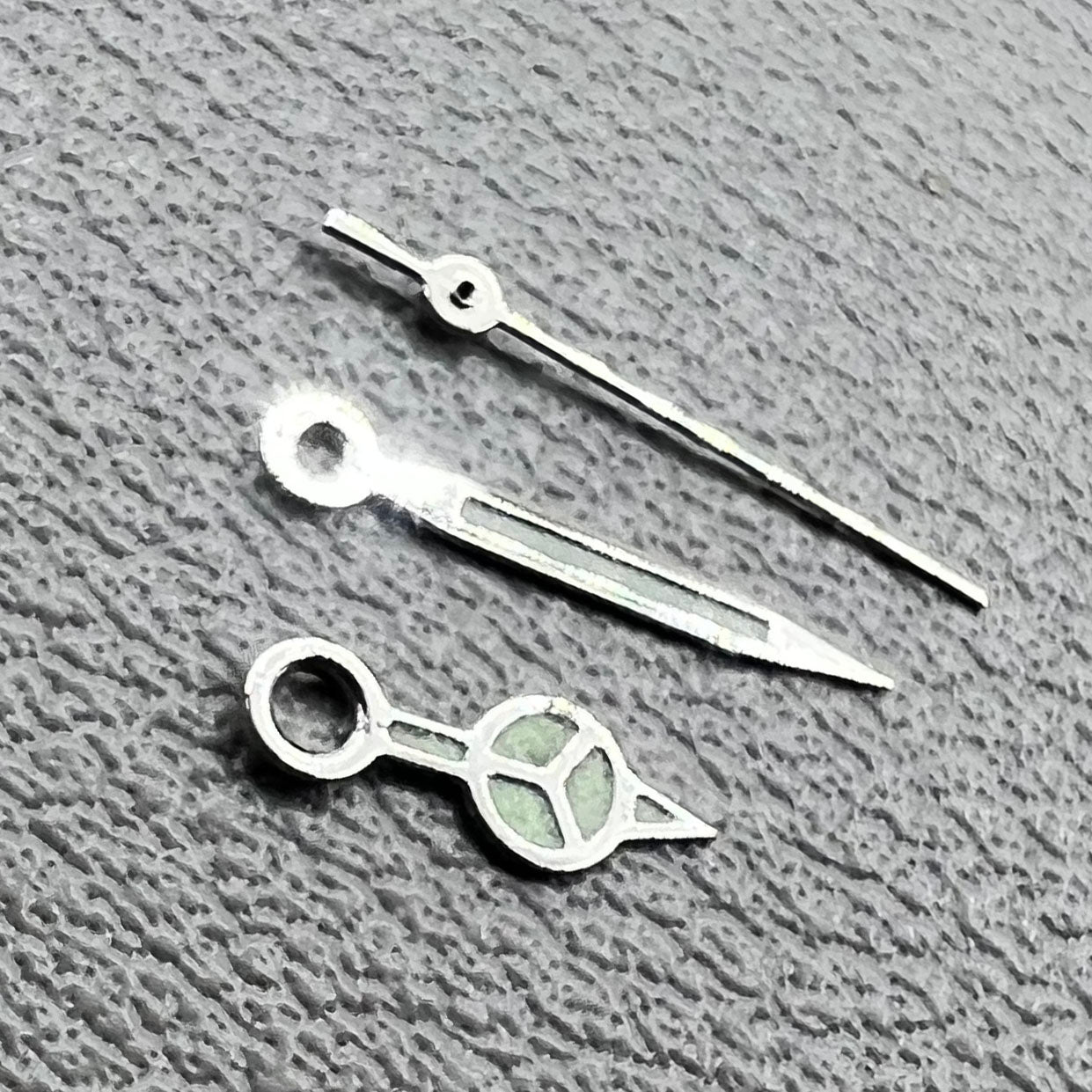 Silver trim green luminous watch hands set for Miyota 1M12 movement, enhancing visibility and style.