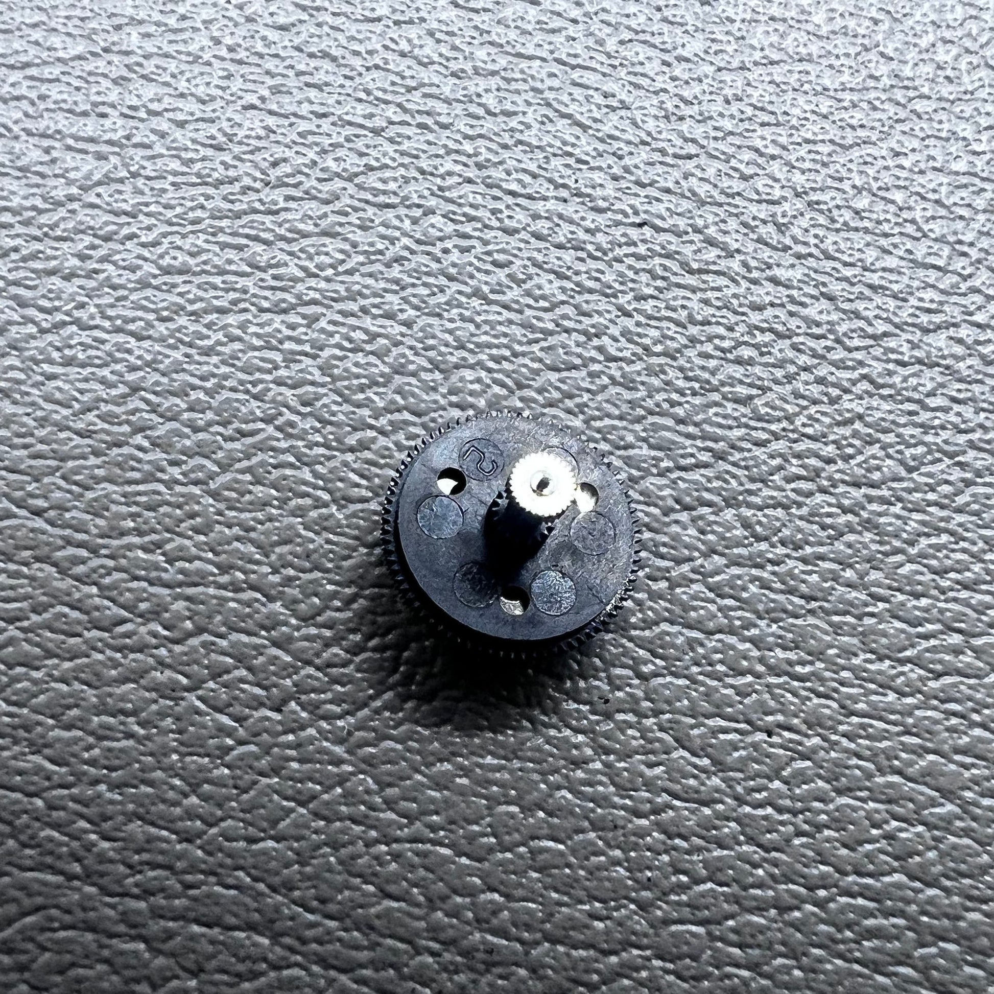 Black counting wheel for ETA C01.211 watch movement, precision replacement part for watch repair.