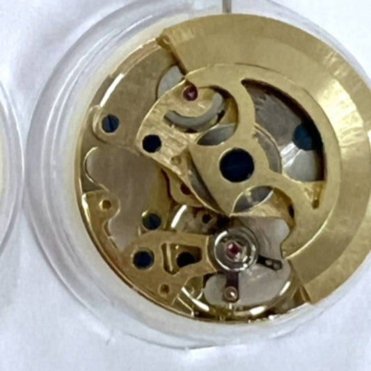 Dandong 7120 golden mechanical watch movement showcasing 3 hands and hollow design with automatic fork mechanism.