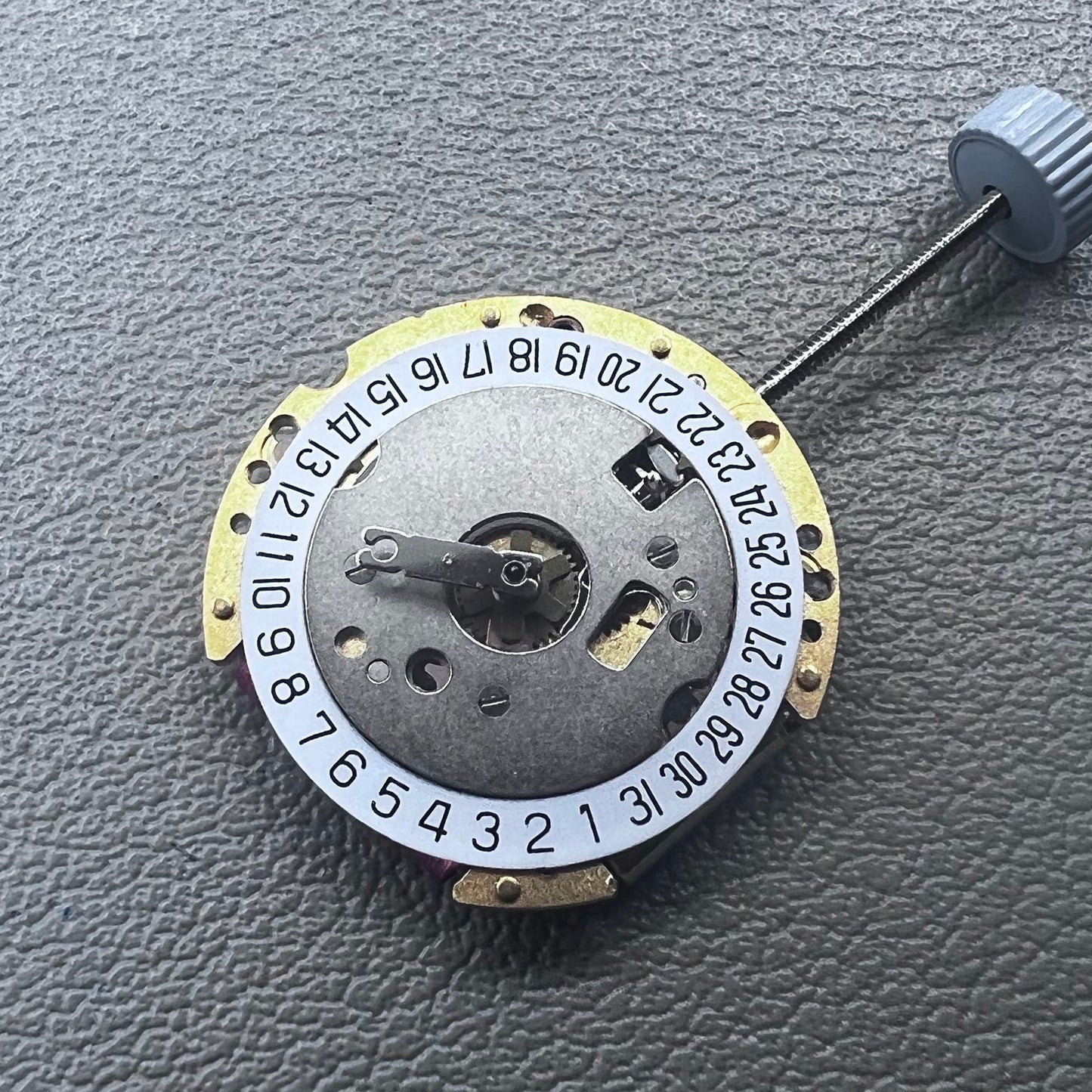 Swiss Ronda 775 quartz watch part with white date disk at 6 o'clock, ideal for precise repairs.