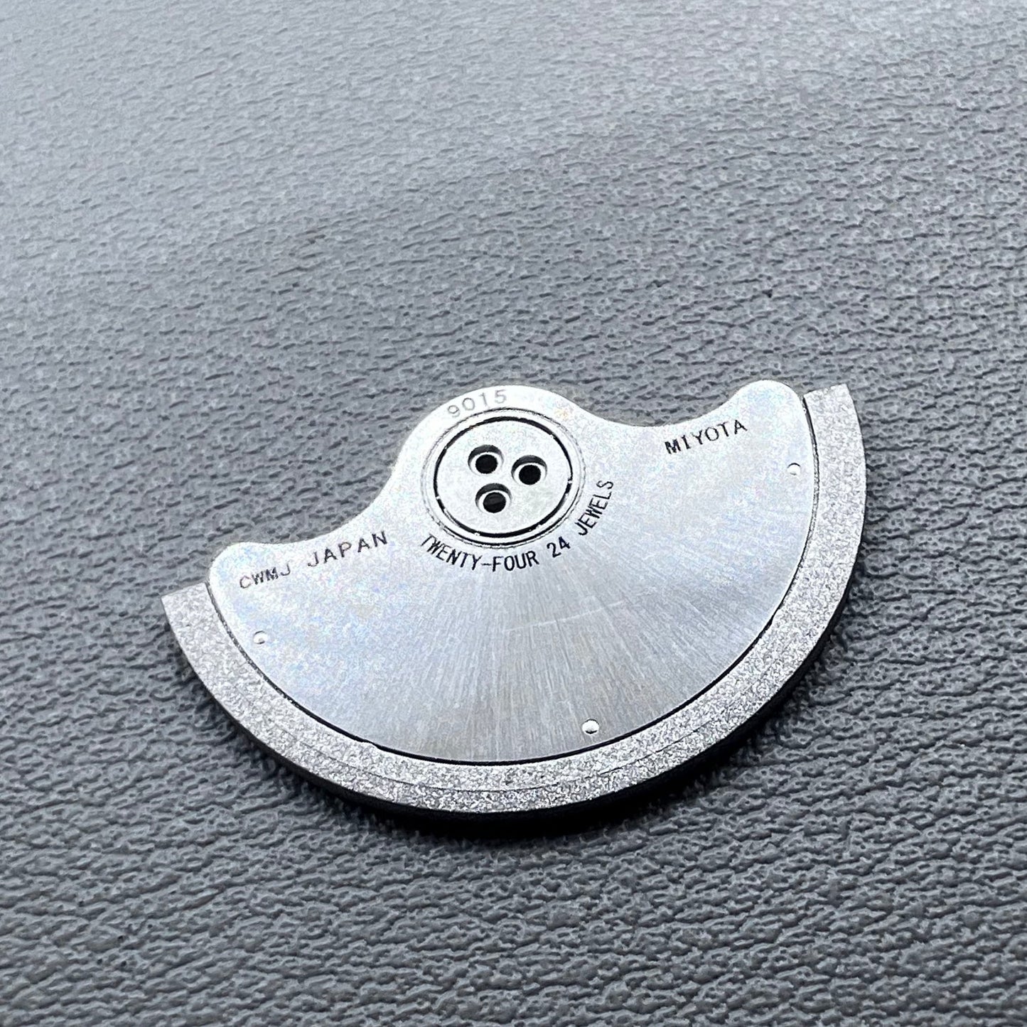 Silver rotor oscillating weight for Miyota 9015 mechanical watch movement, enhancing winding efficiency.