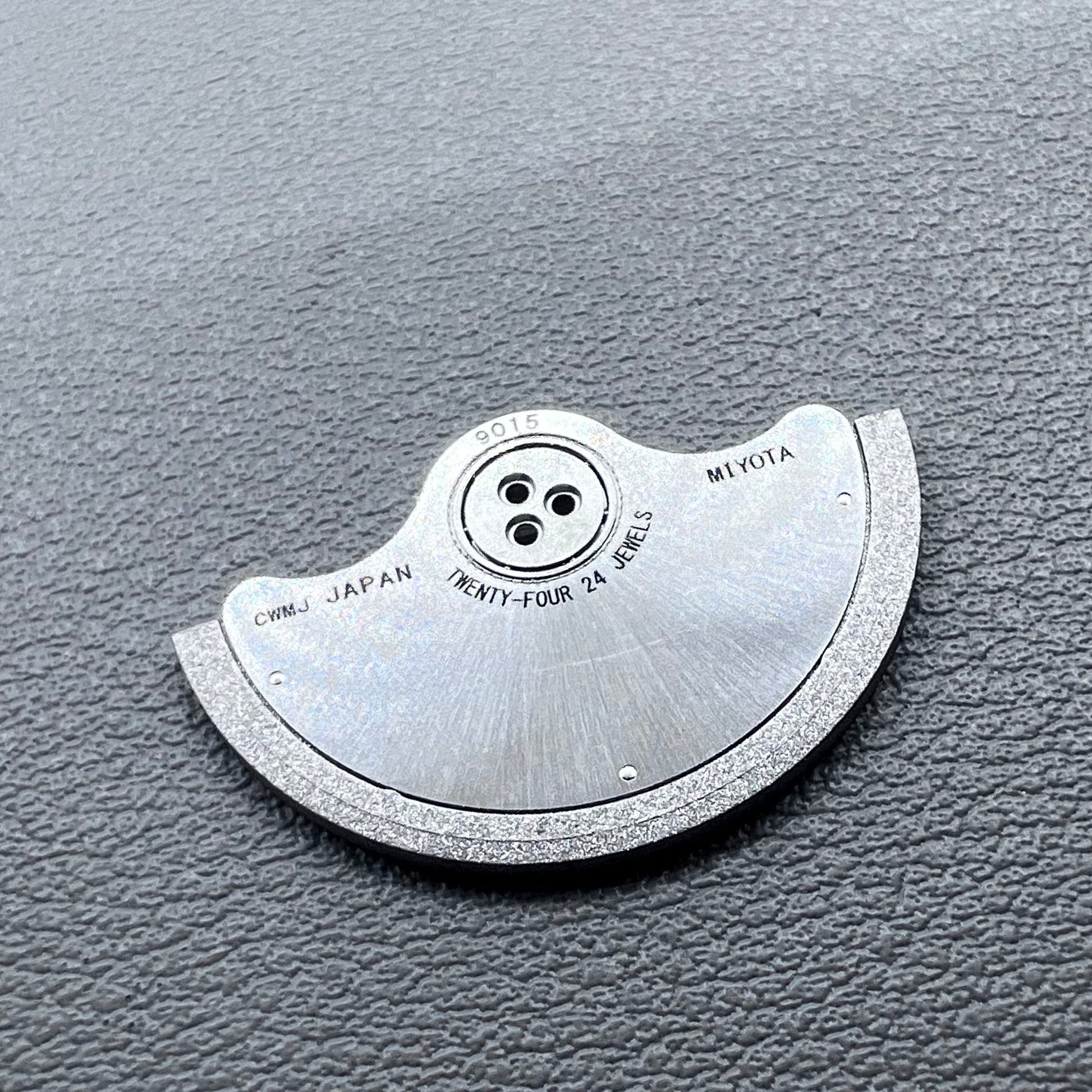 Silver rotor oscillating weight for Miyota 9015 mechanical watch movement, enhancing winding efficiency.