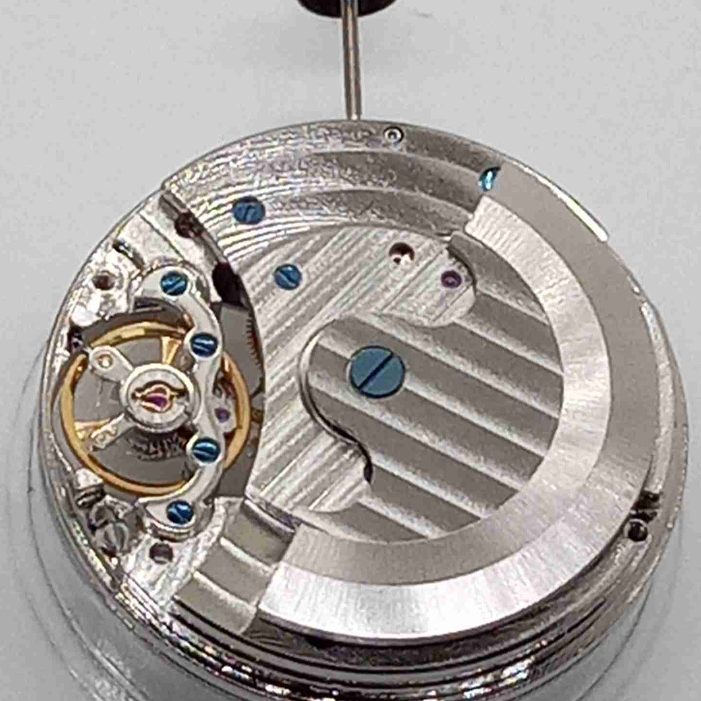 Silver mechanical flywheel watch part, precision movement component for watch repair and assembly.