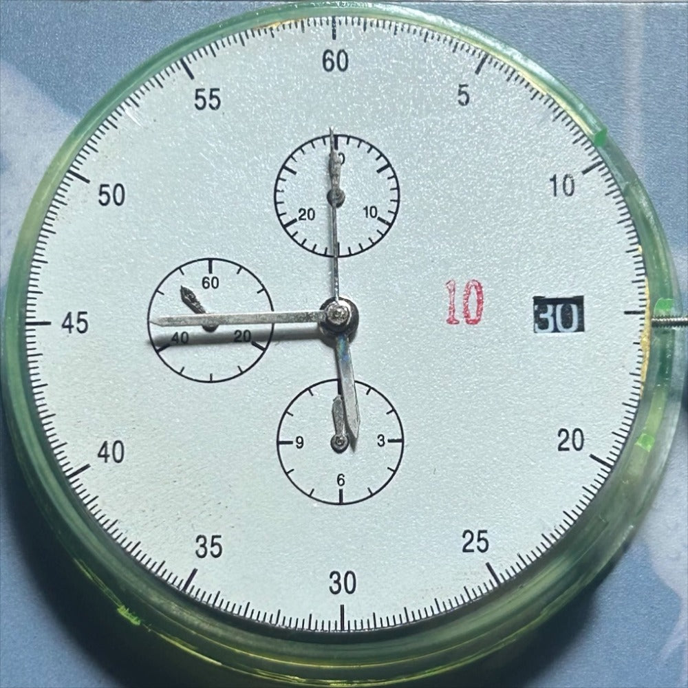 Dandong 7750 mechanical watch movement with small seconds at 6, 9, and 12 o'clock on black dial, precision-engineered.