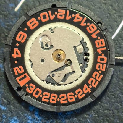 Swiss ISA 2320 quartz watch movement with black dial, orange numerals, date display at 6 o'clock.