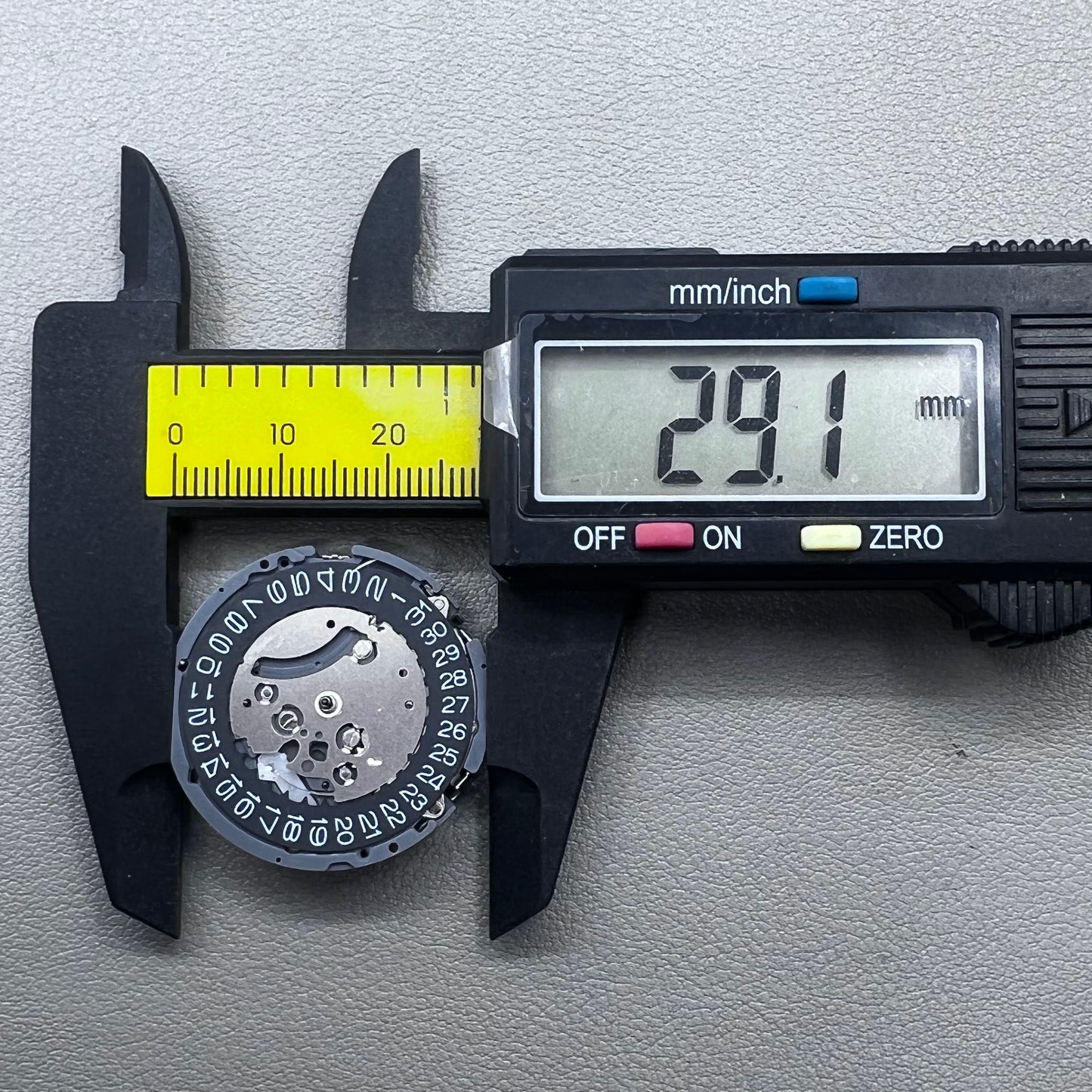 Japan Seiko VK63 quartz watch movement with black disk and white font for precise timekeeping.