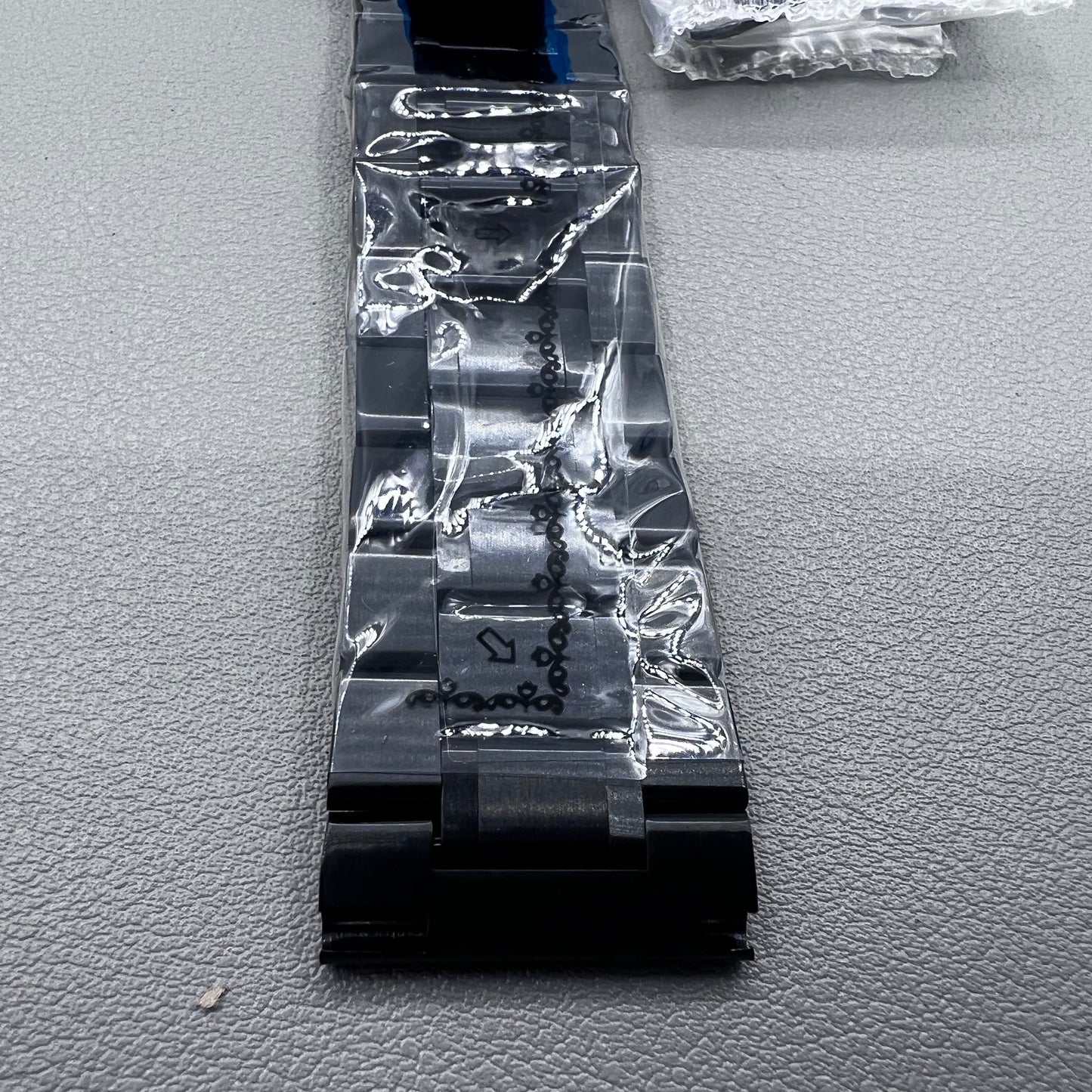 Curved end black steel 23mm watch band with butterfly clasp, durable and stylish.