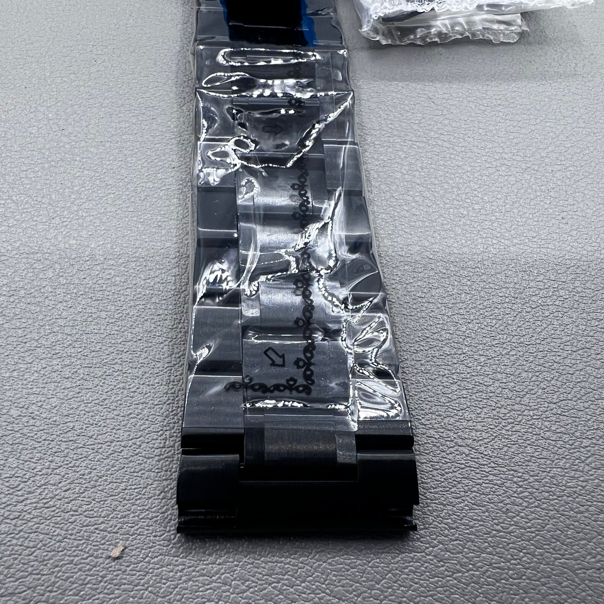 Curved end black steel 23mm watch band with butterfly clasp, durable and stylish.