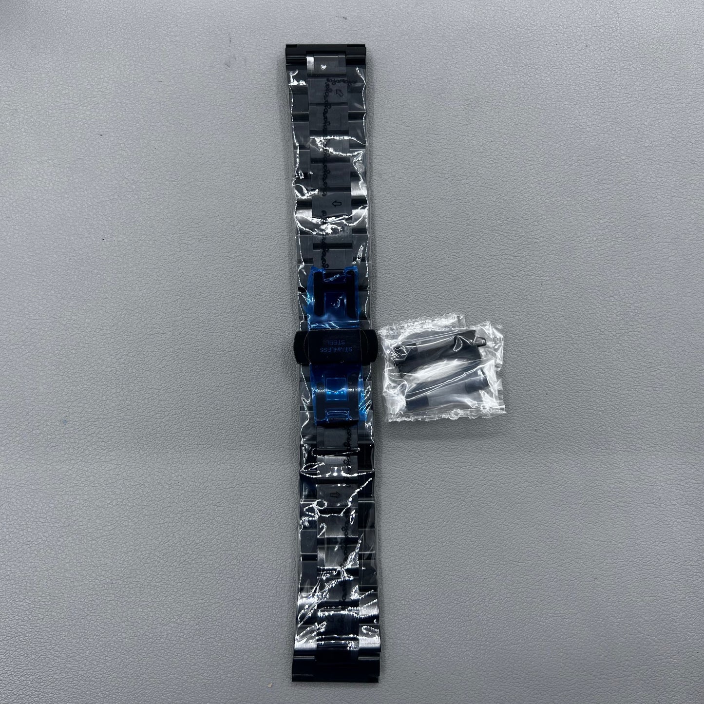 Curved end black steel 23mm watch band with butterfly clasp, durable and stylish.