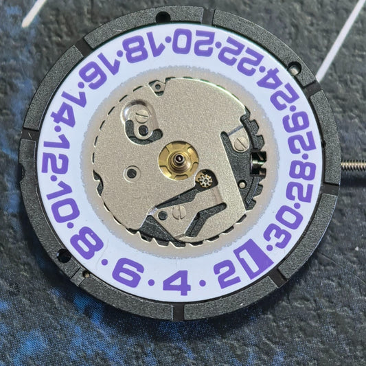 Swiss ISA 2320 quartz watch part with white disk and purple font for precise timekeeping and styling.