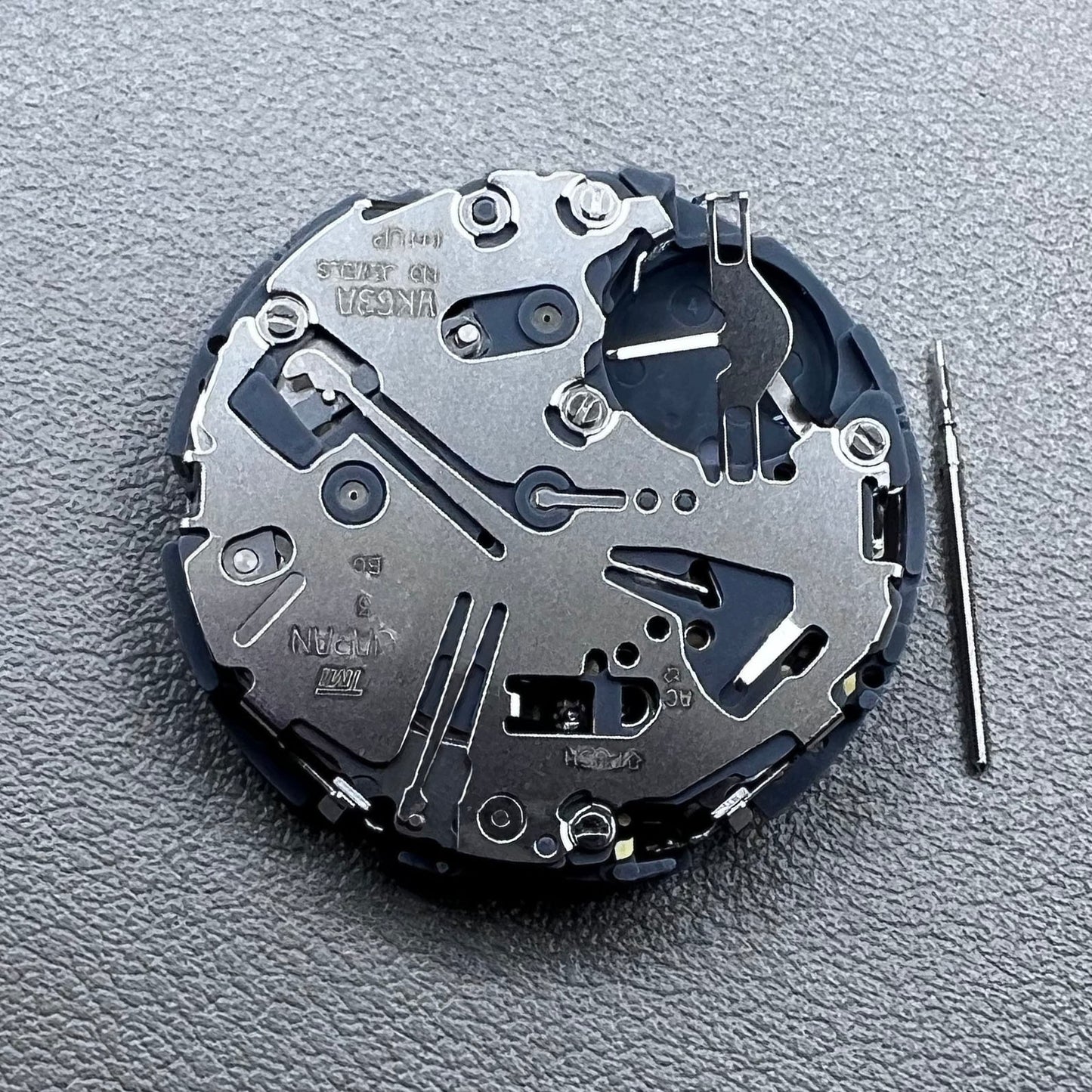 Japan Seiko VK63 quartz watch movement with black disk and white font for precise timekeeping.