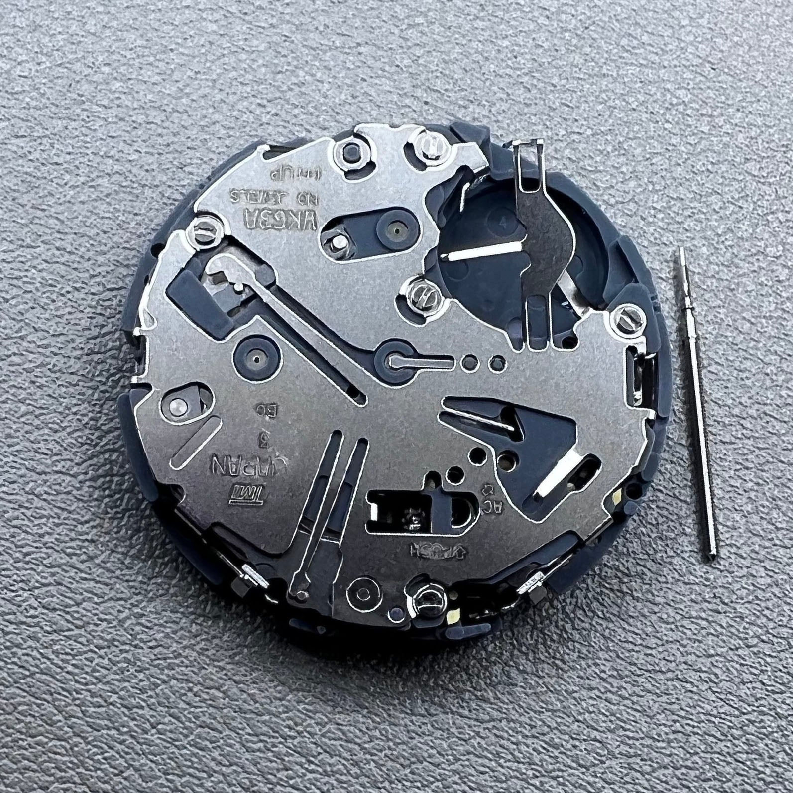 Japan Seiko VK63 quartz watch movement with black disk and white font for precise timekeeping.