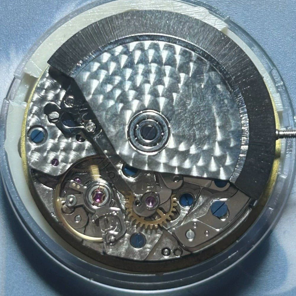 Dandong 7750 mechanical watch movement showing small seconds at 6, 9, 12 and date at 3 positions.