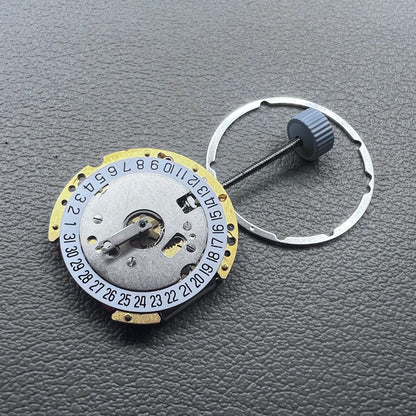 Swiss Ronda 775 quartz watch movement with golden finish, date at 6, and three hands.