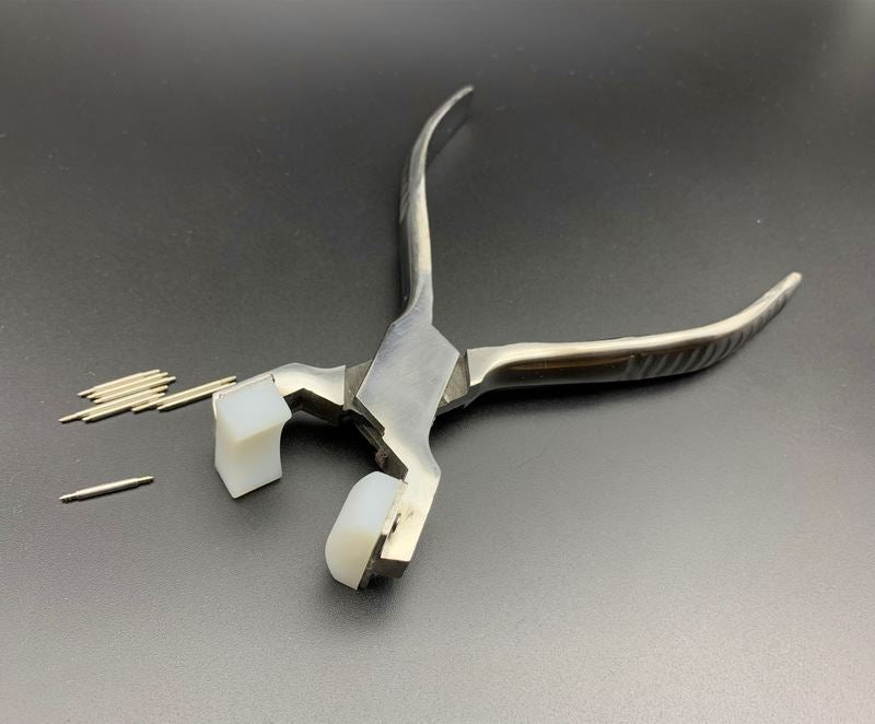 Spring shaft pliers for precise watchband adjustment with steel bracelet and connecting ear rod.