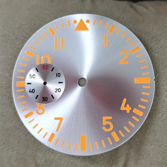 Silver 38.9mm pilot watch dial with orange luminous markers for ETA 6497 movement.