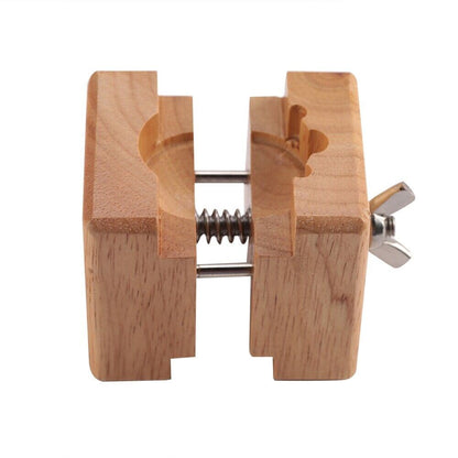 Wooden watch case holder block for secure watch repair and maintenance.