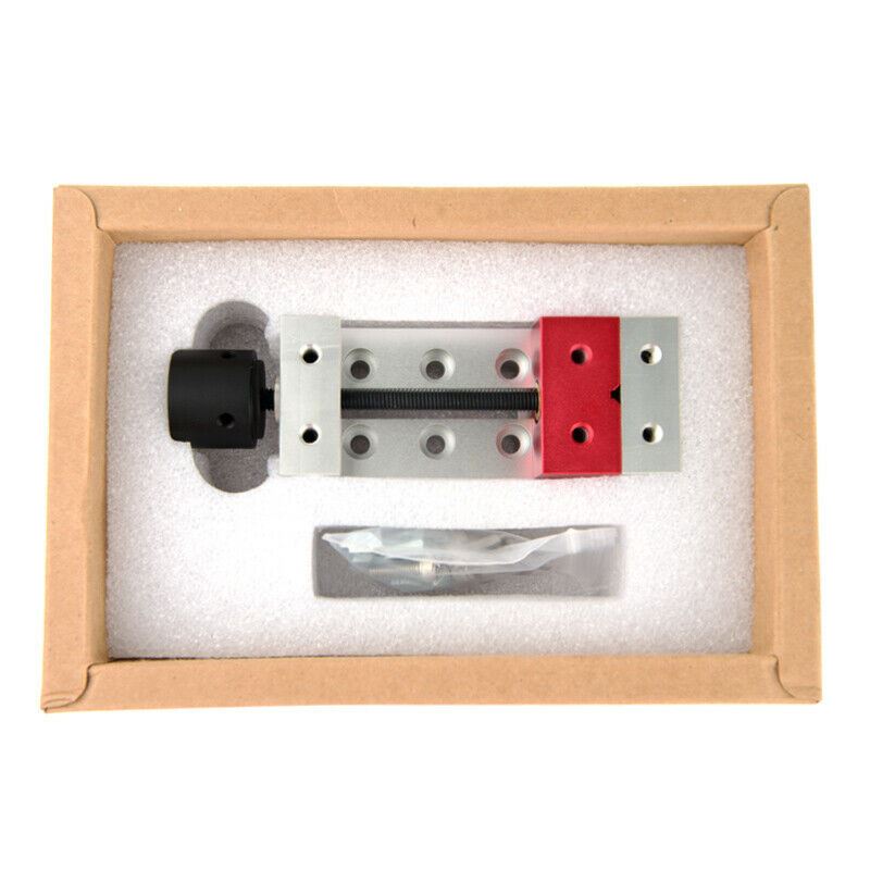 Compact 50mm aluminum clamp bench vise securing drill press and carving tools for precise work.