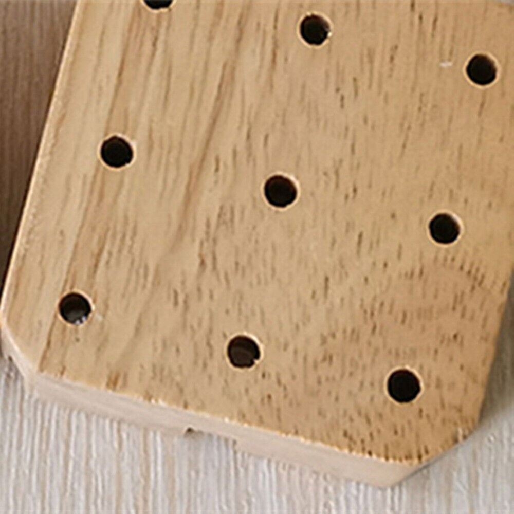 Wooden watch band holder with strap pin remover tool for precise watch repair and adjustment.