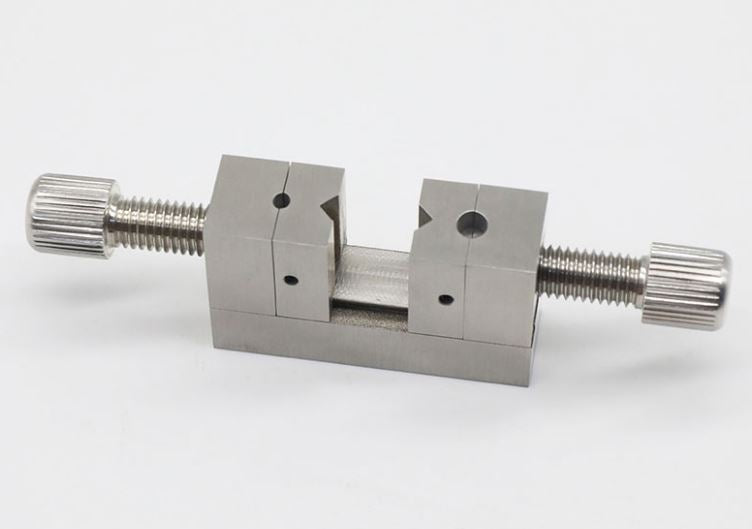 Multi-hole clamp tool for precise watch crown positioning and repair tasks.