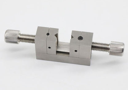 Multi-hole clamp tool for precise watch crown positioning and repair tasks.
