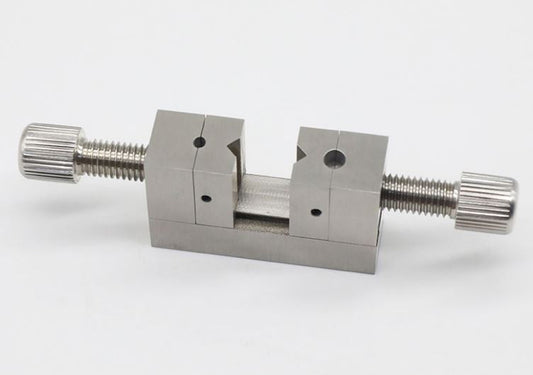Multi-hole clamp tool for precise watch crown positioning and repair tasks.