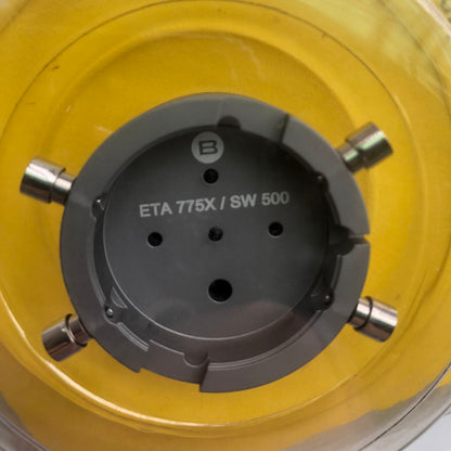 Bergeon 7100 watch movement holder securing ETA 775X Valjoux, precise tool for watch repairs.