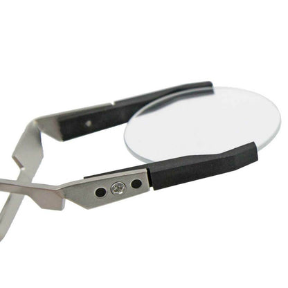 Bergeon 7140 cross locking tweezers gripping watch crystal, precision tool for dial assembly and repair.