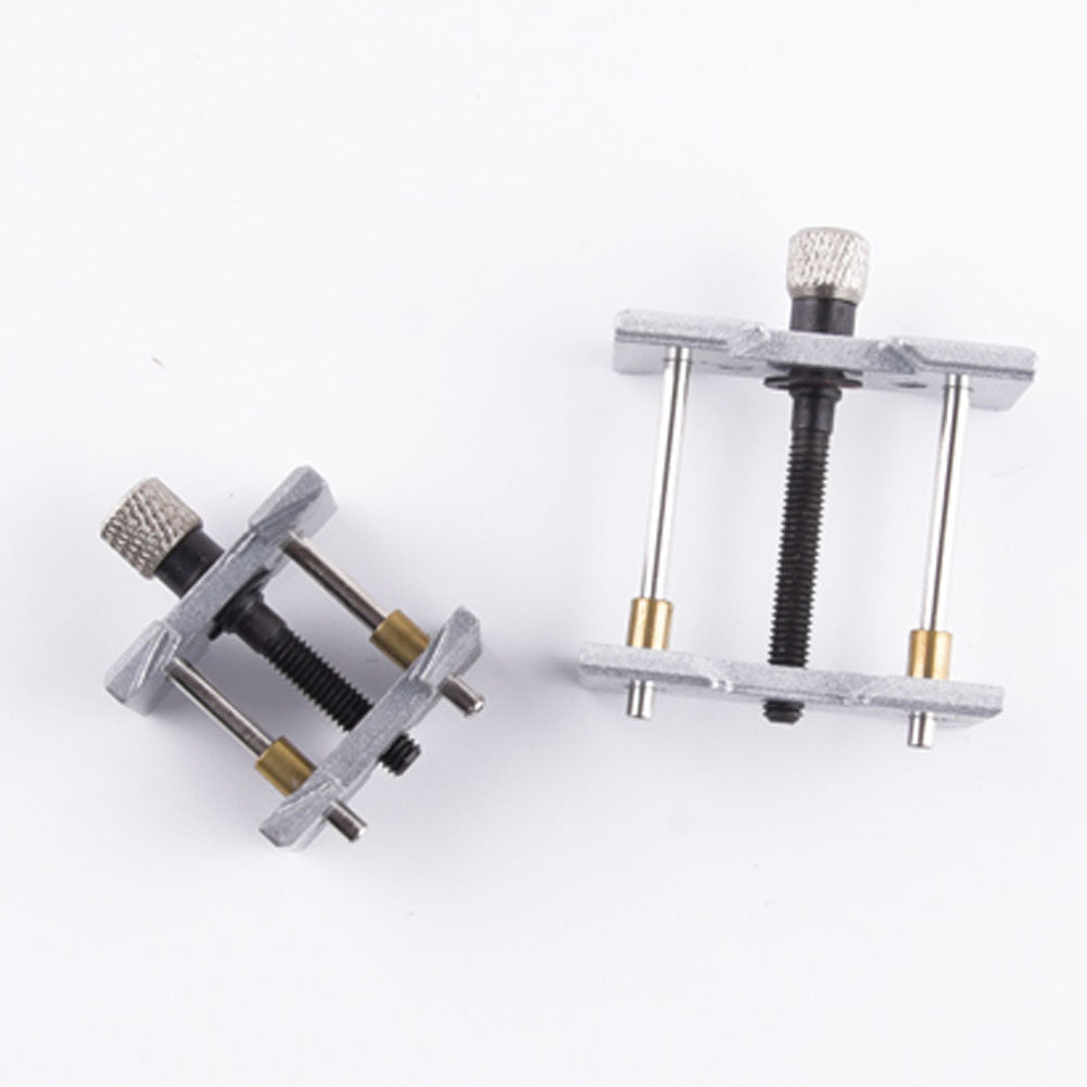 Metal watchmaker clamp and movement holder set for precise watch case repairs.