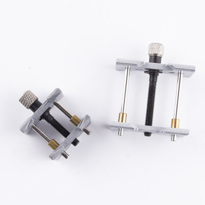 Metal watchmaker clamp and movement holder set for precise watch case repairs.