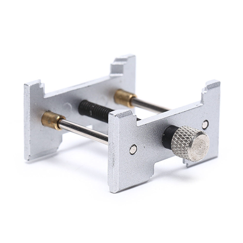 Metal watchmaker clamp and movement holder set for precise watch case repairs.