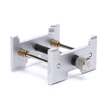 Metal watchmaker clamp and movement holder set for precise watch case repairs.