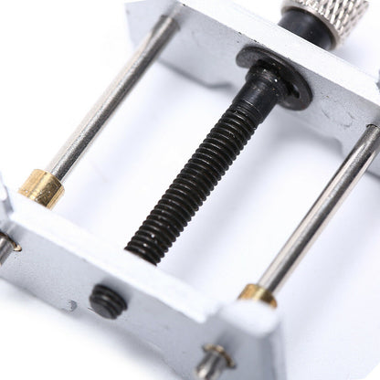 Metal watchmaker clamp and movement holder tool set for precise watch case repairs.
