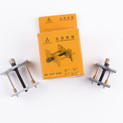 Metal watchmaker clamp and movement holder tool set for precise watch case repairs.